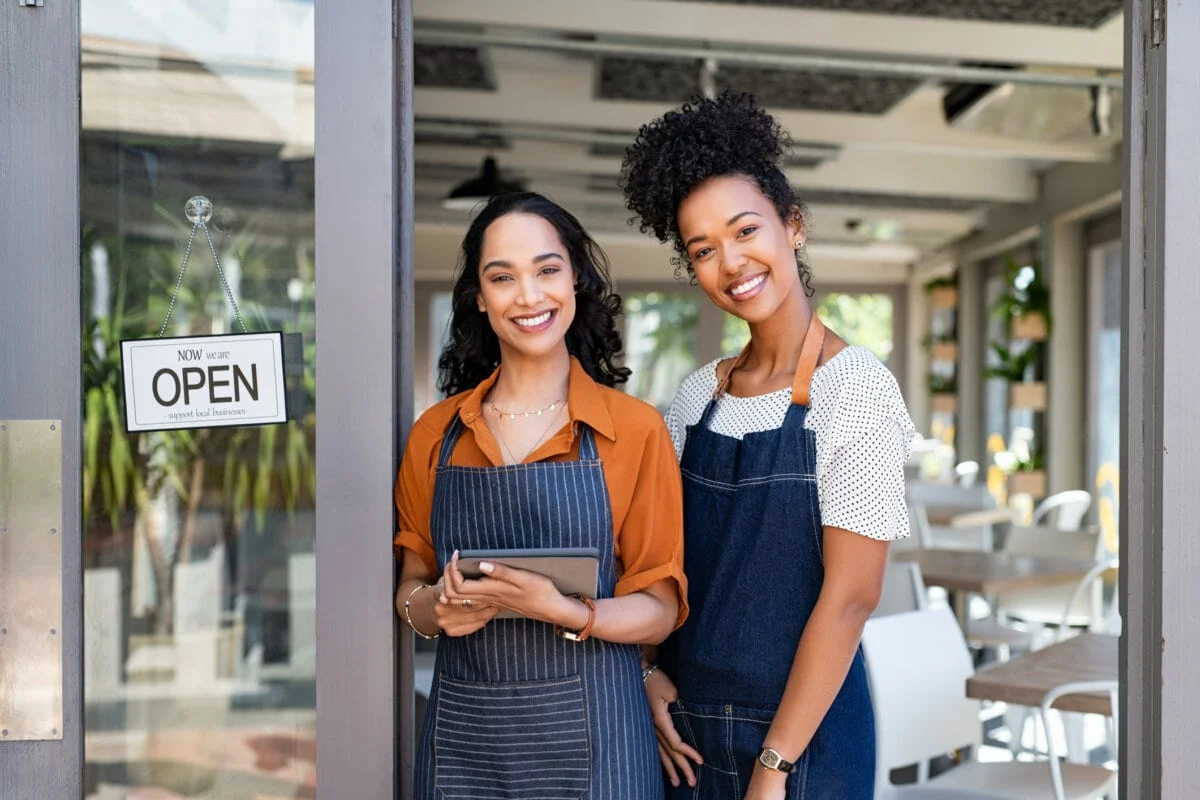 Female business owners standing in their shop doorway